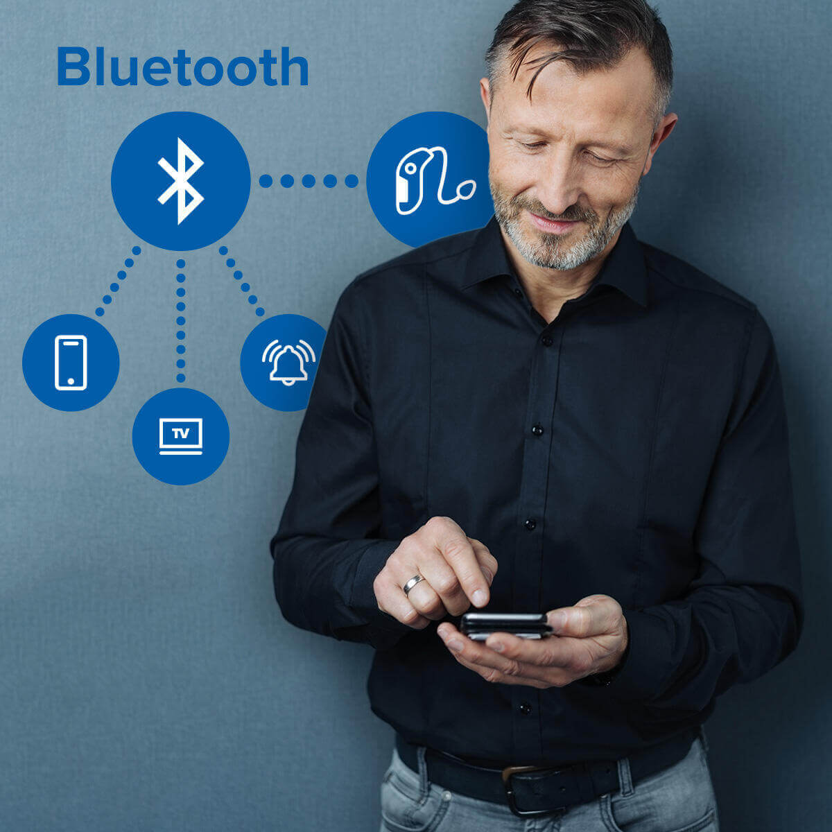 Man using Bluetooth hearing aids with his phone.