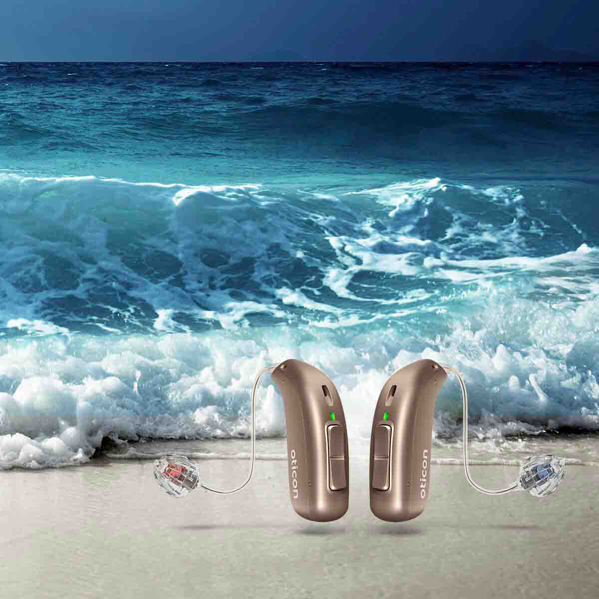 A pair of hearing aids with ocean waves in the background